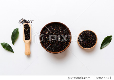 quinoa seeds in bowl and spoon on colored background. Healthy kinwa in small bowl. Healthy superfood quinoa seeds in bowl and spoon on colored background. Healthy kinwa in small bowl. Healthy superfood 139846871