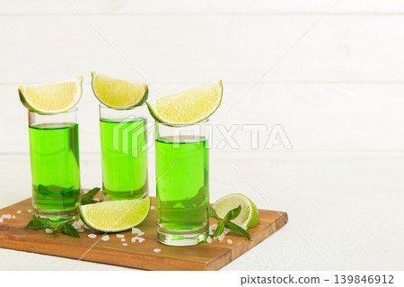 Sweet refreshing mint liqueur, with ice and mint leaves on table background, Shots with lime slice and mint flat lay Sweet refreshing mint liqueur, with ice and mint leaves on table background, Shots with lime slice and mint flat lay 139846912