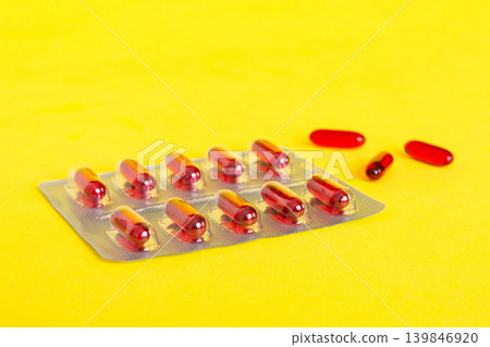 Blister package with Vitamin a on color background. Medicine pills on a light background. Medicines and prescription pills flat lay background. red medical tablets in blister Blister package with Vitamin a on color background. Medicine pills on a light background. Medicines and prescription pills flat lay background. red medical tablets in blister 139846920