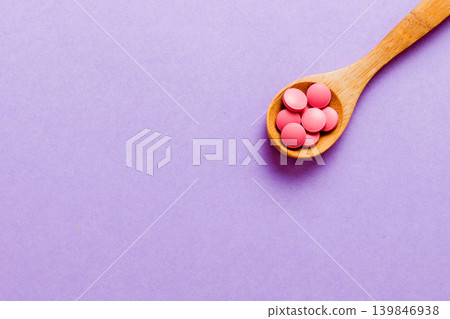 Vitamin capsules in a spoon on a colored background. Pills served as a healthy meal. Red soft gel vitamin supplement capsules on spoon Vitamin capsules in a spoon on a colored background. Pills served as a healthy meal. Red soft gel vitamin supplement capsules on spoon 139846938