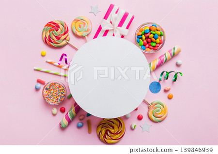 Flat lay holiday composition. Paper blank, lollipop, birthday decorations on Colored background. Top view, copy space for text Flat lay holiday composition. Paper blank, lollipop, birthday decorations on Colored background. Top view, copy space for text 139846939