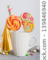 Colorful candies in cup on table on light background background. Large swirled lollipops. Creative concept of a jar full of delicious sweets from the candy store 139846940
