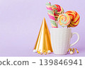 Colorful candies in cup on table on light background background. Large swirled lollipops. Creative concept of a jar full of delicious sweets from the candy store 139846941