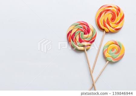 Set of colorful lollipops on colored background. Summer concept. Party Happy Birthday or Minimalist Concept Set of colorful lollipops on colored background. Summer concept. Party Happy Birthday or Minimalist Concept 139846944