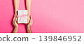 Top view of holding a gift in female and male hands on colorful background. Woman and man give and receive a present. Time for holiday concept with copy space 139846952