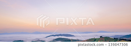 Breathtaking mountain panorama with dense white fog and clouds at dawn featuring soft pastel sky colors creating peaceful natural landscape perfect for travel tourism and wellness marketing materials Breathtaking mountain panorama with dense white fog and clouds at dawn featuring soft pastel sky colors creating peaceful natural landscape perfect for travel tourism and wellness marketing materials 139847306