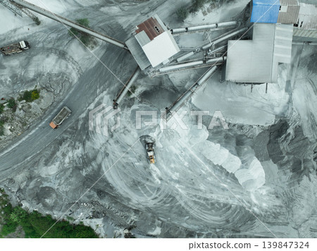 Aerial view of granite and limestone crushing plant with dump trucks and excavators processing raw stone into construction aggregates for concrete and infrastructure development. Stone mill factory. Aerial view of granite and limestone crushing plant with dump trucks and excavators processing raw stone into construction aggregates for concrete and infrastructure development. Stone mill factory. 139847324