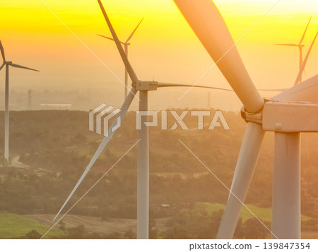 Wind farm field and sunset sky. Wind power. Sustainable, renewable energy. Wind turbines generate electricity. Sustainable development. Green technology for energy sustainability. Eco-friendly energy. Wind farm field and sunset sky. Wind power. Sustainable, renewable energy. Wind turbines generate electricity. Sustainable development. Green technology for energy sustainability. Eco-friendly energy. 139847354