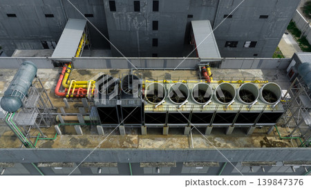Industrial cooling system on factory rooftop. Ventilation fans. Energy efficiency, thermal management. Climate conscious energy management. Reduced emissions and sustainable energy operation. Industrial cooling system on factory rooftop. Ventilation fans. Energy efficiency, thermal management. Climate conscious energy management. Reduced emissions and sustainable energy operation. 139847376