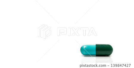 Blue and green antibiotic capsule pills isolated on white background in global healthcare concept showing antimicrobial resistance awareness and responsible drug use for infection treatment. Blue and green antibiotic capsule pills isolated on white background in global healthcare concept showing antimicrobial resistance awareness and responsible drug use for infection treatment. 139847427