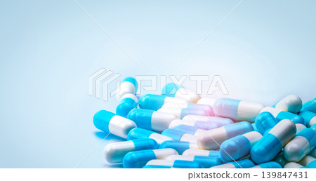 Selective focus on blue and white capsules pill on white background. Antibiotics drug resistance. Antimicrobial capsule pills. Pharmaceutical industry. Pharmacy drugstore products. Pharmaceutics. Selective focus on blue and white capsules pill on white background. Antibiotics drug resistance. Antimicrobial capsule pills. Pharmaceutical industry. Pharmacy drugstore products. Pharmaceutics. 139847431
