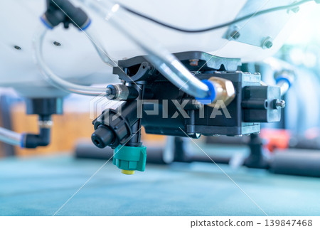 Close-up of a solenoid valve and chemical sprayer nozzle. High-tech agricultural drone, used for precision pesticide and fertilizer spraying in modern smart farming. Automated agriculture systems. Close-up of a solenoid valve and chemical sprayer nozzle. High-tech agricultural drone, used for precision pesticide and fertilizer spraying in modern smart farming. Automated agriculture systems. 139847468
