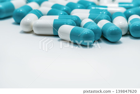 Selective focus on blue and white capsules pill on white background. Antibiotics drug resistance. Antimicrobial capsule pills. Pharmaceutical industry. Pharmacy drugstore products. Pharmaceutics. Selective focus on blue and white capsules pill on white background. Antibiotics drug resistance. Antimicrobial capsule pills. Pharmaceutical industry. Pharmacy drugstore products. Pharmaceutics. 139847620