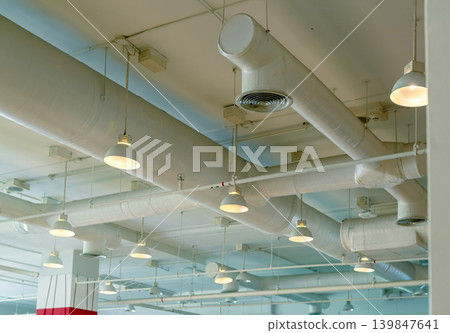Air duct, wiring and plumbing in the mall. Air conditioner pipe, wiring pipe, and plumbing pipe system. Ceiling lamp light with opened light. Building interior concept. Interior architecture concept. Air duct, wiring and plumbing in the mall. Air conditioner pipe, wiring pipe, and plumbing pipe system. Ceiling lamp light with opened light. Building interior concept. Interior architecture concept. 139847641