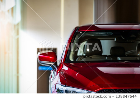 New red luxury SUV compact car parked in modern showroom for sale. Car dealership office. Car retail shop. Electric and hybrid car technology and business concept. Automobile rental concept. New red luxury SUV compact car parked in modern showroom for sale. Car dealership office. Car retail shop. Electric and hybrid car technology and business concept. Automobile rental concept. 139847644