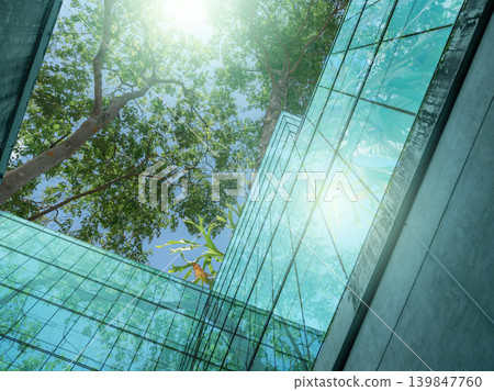 Eco-friendly building in the modern city. Sustainable glass office building with trees for reducing heat and carbon dioxide. Office building with green environment. Corporate building reduce CO2. Eco-friendly building in the modern city. Sustainable glass office building with trees for reducing heat and carbon dioxide. Office building with green environment. Corporate building reduce CO2. 139847760