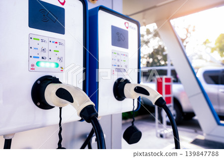 Electric car charging station for charge EV battery. Plug for vehicle with electric engine. EV charger. Clean energy. Charging point at car parking lot. Green power. Future transport technology. Electric car charging station for charge EV battery. Plug for vehicle with electric engine. EV charger. Clean energy. Charging point at car parking lot. Green power. Future transport technology. 139847788