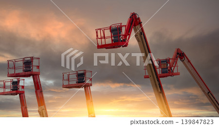 Articulated boom lift. Aerial platform lift. Telescopic boom lift with sunset sky. Mobile construction crane for rent. Repair hydraulic boom lift service. Crane dealership. Safety use of machinery. Articulated boom lift. Aerial platform lift. Telescopic boom lift with sunset sky. Mobile construction crane for rent. Repair hydraulic boom lift service. Crane dealership. Safety use of machinery. 139847823