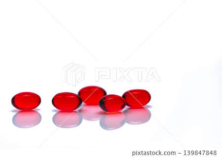 Red soft gel capsule pills isolated on white background. Pile of red soft gelatin capsule. Vitamins and dietary supplements concept. Pharmaceutical industry. Pharmacy drug store. Health care products. 139847848