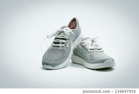 A pair of grey shoes on white background. Comfortable shoes with pore. Breathable rubber shoes. Footwear. A pair of grey shoes on white background. Comfortable shoes with pore. Breathable rubber shoes. Footwear. 139847958