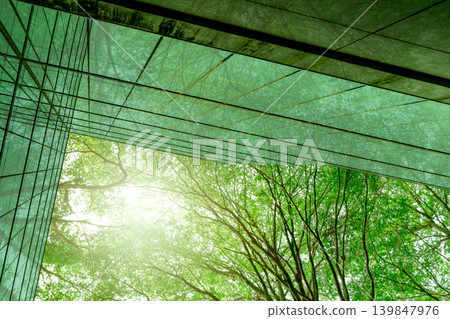 Sustainble green building. Eco-friendly building in modern city. Sustainable glass office building with tree for reducing carbon dioxide. Office with green environment. Corporate building reduce CO2. Sustainble green building. Eco-friendly building in modern city. Sustainable glass office building with tree for reducing carbon dioxide. Office with green environment. Corporate building reduce CO2. 139847976