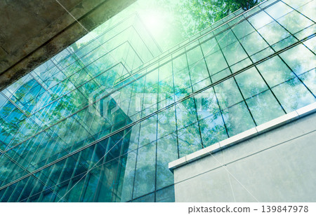 Sustainble green building. Eco-friendly building in modern city. Sustainable glass office building with tree for reducing carbon dioxide. Office with green environment. Corporate building reduce CO2. Sustainble green building. Eco-friendly building in modern city. Sustainable glass office building with tree for reducing carbon dioxide. Office with green environment. Corporate building reduce CO2. 139847978