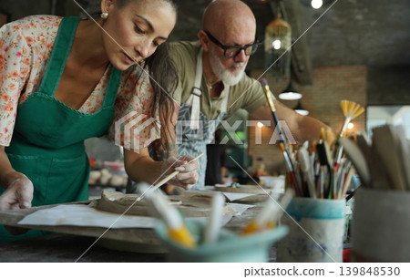 A happy couple makes ceramic plates in a workshop 139848530
