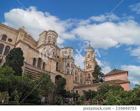 Historic Malaga Cathedral With Tower and Lush Gardens Under a Bright Sky Historic Malaga Cathedral With Tower and Lush Gardens Under a Bright Sky 139849783