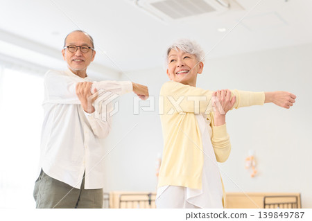 Senior men and women doing stretches at a nursing home. Senior men and women doing stretches at a nursing home. 139849787
