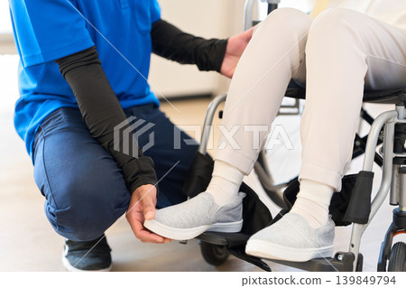 一位坐在輪椅上的老人正由一位外國護理人員照顧。 139849794