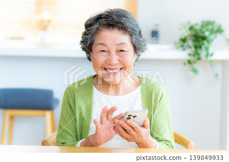 在客廳裡操作智能手機的女高管 在客廳裡操作智能手機的女高管 139849933