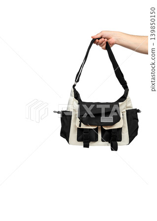 hand holds a black and white bag isolated on a white background hand holds a black and white bag isolated on a white background 139850150