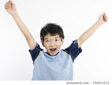 Happy boy in t-shirt raising hands up Happy boy in t-shirt raising hands up 139851672