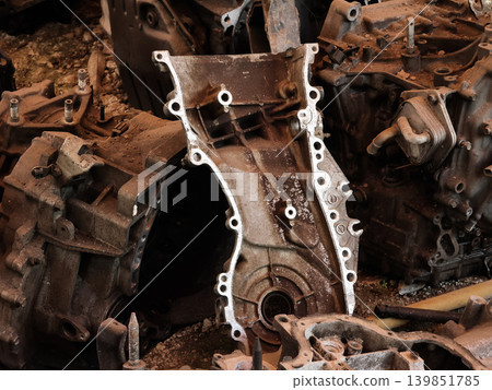 Rusted engine parts and corroded gears scattered across the sandy ground Rusted engine parts and corroded gears scattered across the sandy ground 139851785