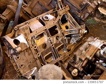 Rusted engine parts and corroded gears scattered across the sandy ground Rusted engine parts and corroded gears scattered across the sandy ground 139851787