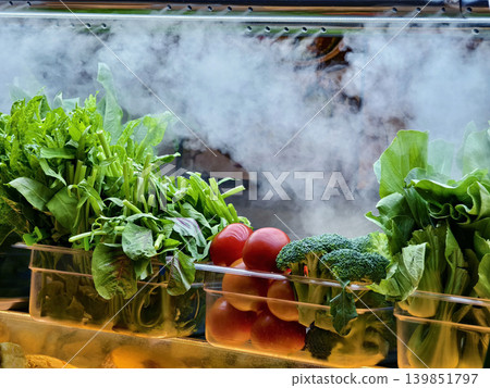 foggy refrigeration creating display with leafy greens and eggplants in glass case foggy refrigeration creating display with leafy greens and eggplants in glass case 139851797