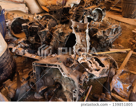 Rusted engine parts and corroded gears scattered across the sandy ground Rusted engine parts and corroded gears scattered across the sandy ground 139851805