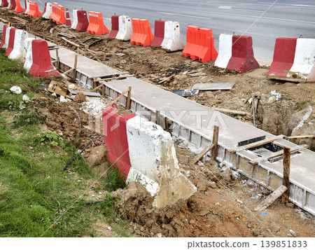Narrow ditch with reinforcement, waterproof concrete trench bounded by soil and support stakes Narrow ditch with reinforcement, waterproof concrete trench bounded by soil and support stakes 139851833