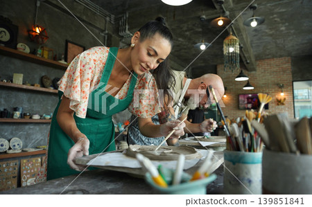 A happy couple makes ceramic plates in a workshop 139851841