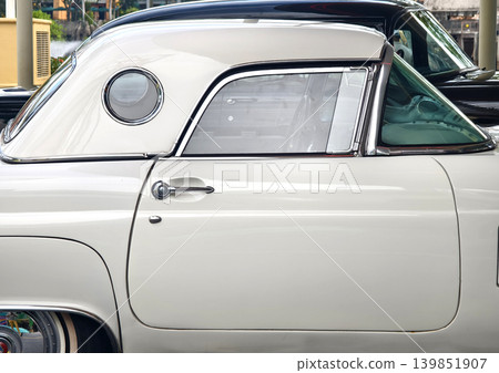 White classic car parked on street, gleaming chrome trim and polished hubcap reflecting sunny urban White classic car parked on street, gleaming chrome trim and polished hubcap reflecting sunny urban 139851907