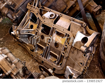 Rusted engine parts and corroded gears scattered across the sandy ground Rusted engine parts and corroded gears scattered across the sandy ground 139851927
