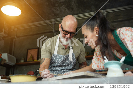 A happy couple makes ceramic plates in a workshop 139851962