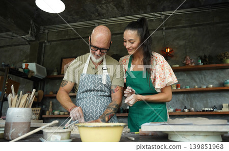 A happy couple makes ceramic plates in a workshop 139851968