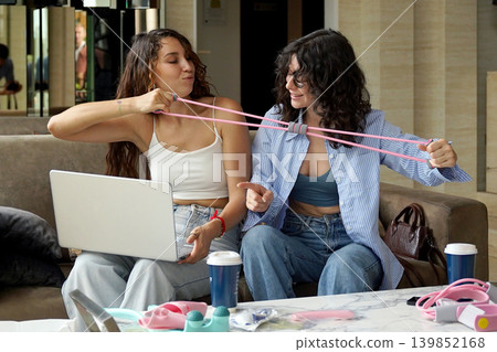 Two young women run a blog and sell massagers through a website Two young women run a blog and sell massagers through a website 139852168