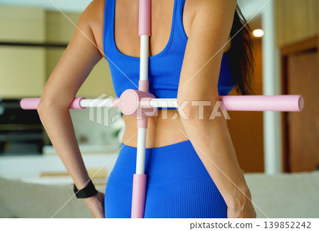 Woman blue sportswear using physiotherapy device to correct his posture Woman blue sportswear using physiotherapy device to correct his posture 139852242