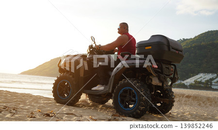 A man engages in extreme ATV riding on sand beach early in the morning A man engages in extreme ATV riding on sand beach early in the morning 139852246