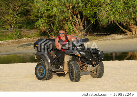 A man engages in extreme ATV riding on sand beach early in the morning A man engages in extreme ATV riding on sand beach early in the morning 139852249