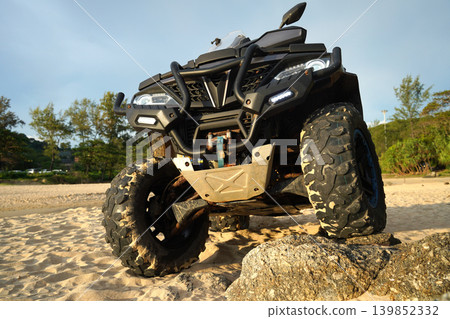 A man engages in extreme ATV riding on sand beach early in the morning A man engages in extreme ATV riding on sand beach early in the morning 139852332
