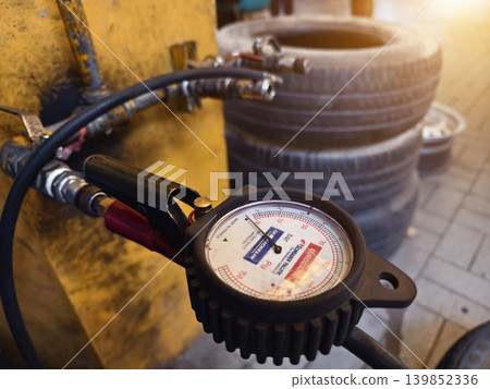 Workshop tire pressure, Inflator connected to compressor, Industrial setting with gauges and tires 139852336