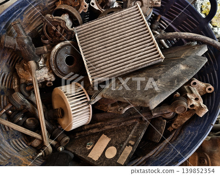 Rusted engine parts and corroded gears scattered across the sandy ground Rusted engine parts and corroded gears scattered across the sandy ground 139852354